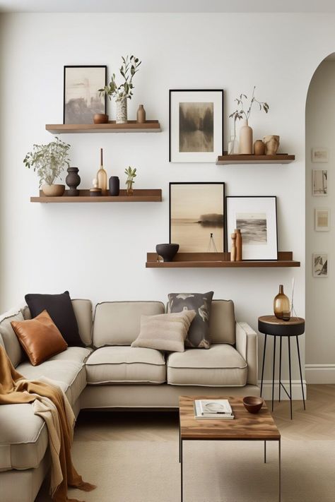 Shelf With Paintings, How To Hang Up Photos Wall Ideas, Couch Wall Art Ideas, Pictures On Wall Ideas Living Room Layout Floating Shelves, Plain Walls Ideas, Gallery Wall With Greenery, Plain Wall Living Room Ideas, Picture Wall Ideas Shelves, Homey Earthy Living Room