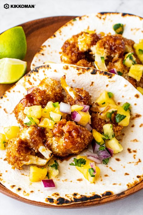 Image shows 2 soft tacos on a wooden plate with lime wedges off to the side. Each taco has a few Panko-breaded cauliflower florets with a scoop of bright yellow pineapple salsa on top. There is a Kikkoman logo at the top left corner of the photo. Breaded Cauliflower Tacos, Hawaiian Vegetarian Recipes, Tropical Dinner Recipes, Luau Brunch, Hawaiian Tacos, Hawaiian Appetizers, Pineapple Tacos, Homemade Dipping Sauce, Breaded Cauliflower