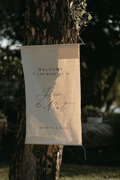 Fabric wedding welcome sign hung on a tree with sun shining through Wedding Welcome Sign Canvas, Canvas Wedding Signs, Fabric Wedding Sign, Fabric Welcome Sign, Welcome Table Wedding, Canvas Welcome Sign, Peterborough Ontario, Welcome Flowers, Wedding Welcome Board