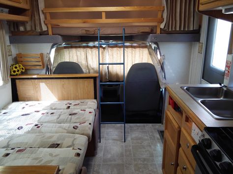 Dining area converted into bed showing the over cab bed set up and ladders Class C Rv Remodel, Rv Class C, Rv Updates, Luxury Caravans, Rv Remodel Ideas, Converted Vans, Camper Remodeling, Class C Rv, Rv Makeover