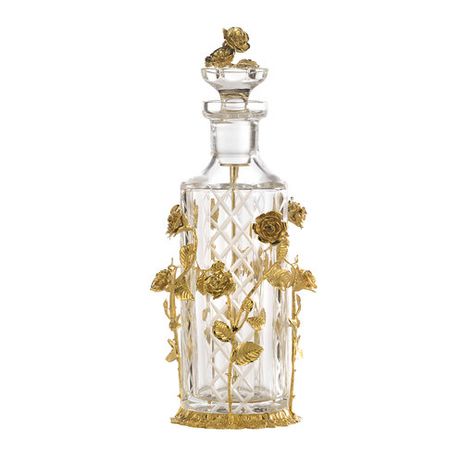 Symbol of love and romance, gilded roses dance along this mouth-blown crystal bottle engraved by hand with a diamond pattern that enhances its luminous and evocative quality. Handcrafted by master artisans, the bottle (450 ml) rests on a round base and is surrounded by exquisite long-stemmed roses of lost wax casting bronze illuminated by a mirror-polished 24k gold plating. The stopper showcases a bouquet of roses and is equipped with a stick applicator. Available also in amber crystal, silver p Rose Perfume Bottle, Elegant Perfume Bottles, Luxury Perfume Bottle, Uni Vibes, Rose Gold Clothes, A Bouquet Of Roses, Crystal Bottle, Perfume Bottle Design, Stone Vase