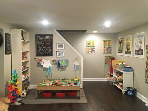 Basement Playroom decor reading area train table and puzzles Finished Basement Playroom, Unfinished Basement Playroom, Narrow Basement Ideas, Basement Play Area, Small Finished Basements, Home Daycare Ideas, Open Basement, Low Ceiling Basement, Daycare Decor