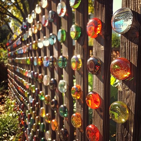 “A fence with colorful marbles is a whimsical and eye-catching addition to any garden or yard 🌈🏡. By embedding vibrant glass marbles into the holes of a wooden fence, sunlight filters through, creating a dazzling display of colors and light effects that transform your outdoor space ✨🌞. This DIY project is not only easy and affordable but also adds a unique artistic touch to your fence, making it a standout feature in your neighborhood 🌺😊.” Marble In Fence, Marbles In Fence, Marble Fence, Urban Gardening, Wooden Fence, Glass Marbles, Light Effect, Urban Garden, Garden Ideas