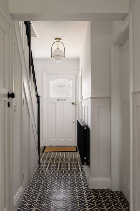 Charlotte Bucciero Interiors | The use of these striking monochrome encaustic cement tiles elevates the entrance hall of this 1930s property. The dark flooring is practical for a high traffic area but is softened by a delicate pattern that makes the hallway feel welcoming. The simple colour palette feels refined and elegant but the tiles and panelling add character and create a homely entrance to this family home. Dark Flooring, Ensuite Bathroom Designs, Spatial Planning, Dining Corner, Hallway Colours, Wooden Panelling, Study Room Design, Dark Floors, Encaustic Cement Tile