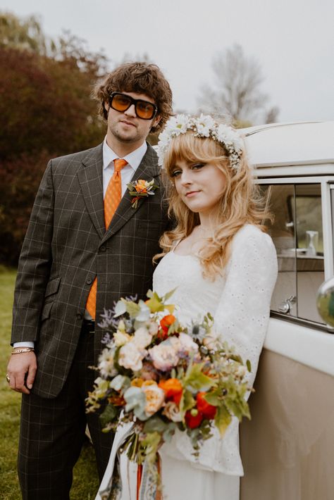 Bride in long bell sleeve boho lace wedding dress with white flower crown hair accessory holding colourful bouquet with groom in brown checkered suit and orange tie with chunky sunglassses for 70s inspired wedding | vintage wedding fashion | retro wedding | wedding photography | The Portfolio People 70s Style Wedding Hair, 70 Wedding Dress Vintage 70s, Wedding 70s Style, Wedding 70s, 70s Style Wedding, 70s Wedding Hair, 70s Wedding Theme, 70s Bride, 70s Wedding