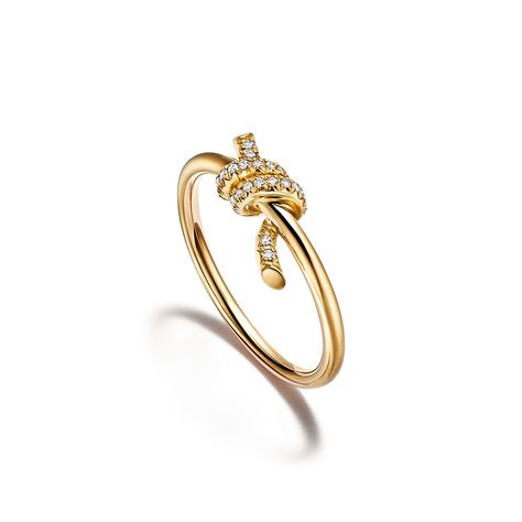 Tiffany Knot is an expression of love’s unwavering bonds. Inspired by an archival bow crafted in 1889, Knot is a symbol of life’s most enduring ties and meaningful connections. This ring is crafted with yellow gold and pavé diamonds, then polished by hand for high shine. Each round brilliant diamond—specifically chosen to meet Tiffany’s high standards—is hand set at precise angles to maximize brilliance. Wear this ring on its own or partnered with classic silhouettes for an unexpected pairing. Tiffany Sixteen Stone Ring, Tiffany And Co Knot Ring, Tiffany Band Ring, Gold Tiffany Ring, Tiffany And Co Gold Ring, Gold Tiffany Jewelry, Tiffany Gold Jewelry, Tiffany Ring Gold, Tiffany Engagement Ring Gold