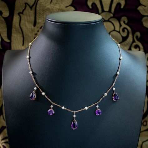 New in! A gorgeous antique Victorian amethyst pearl necklace adorned with five droppers set with round and pear-cut amethysts ranging from 1.8 – 3ct each. They have a luxurious deep-purple hue that is complemented perfectly by nineteen bright white pearls set above and along the length of the chain. The chain and droppers are fashioned in 15ct gold and fitted with a new 9ct ring clasp. It dates to the late 19th Century would be perfect for a glamorous evening do. Get it with 30% off when y... Victorian Accessories Jewellery, Regal Jewelry, Amethyst Jewelry Necklace, British Crown Jewels, Victorian Accessories, Victorian Jewellery, Edwardian Engagement Ring, Purple Jewelry, Purple Necklace