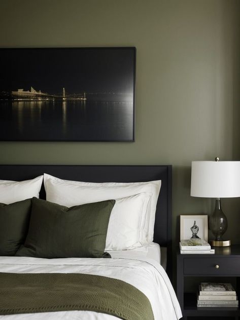 Create a stunning focal point in your bedroom with a dark olive green accent wall. Pair it with a crisp white bedspread, a sleek black nightstand, and a statement piece of artwork to bring the room to life. Olive Green Accent Wall, Black Headboard Bedroom, Olive Green Bedroom, Olive Bedroom, Green Accent Wall, Olive Green Bedrooms, White Bedspread, Green Bedroom Decor, Olive Green Walls