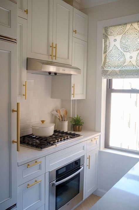 Tiny white kitchen boasts big sophisticated features with white cabinets and brushed gold pulls. Tiny White Kitchen, White Shaker Kitchen, Shaker Kitchen Cabinets, Condo Kitchen, Transitional Decor Kitchen, Small Kitchen Decor, Casa Container, Gold Kitchen, Kitchen Hardware