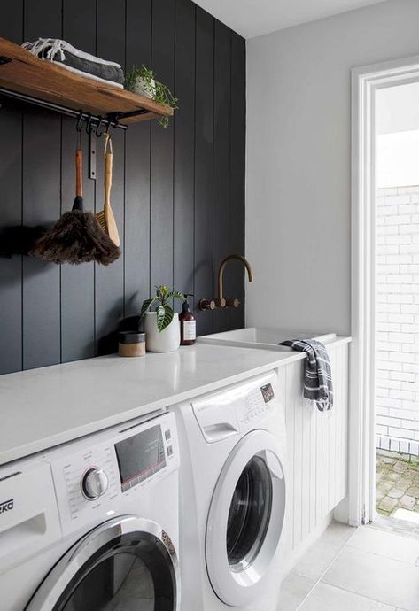 a contrasting laundry with a black shiplap wall, a white shiplap cabinet, white appliances and a countertop plus a door to the garden Laundry Shelves, Chic Beach House, White Laundry Rooms, Stylish Laundry Room, White Laundry, Laundry Room Renovation, Laundry Design, Modern Laundry Rooms, Laundry Room Shelves