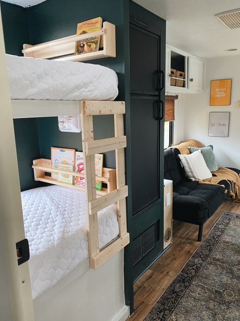 Bunkroom. Camper ladder. Camper bunk remodel. Dark paint color. Green walls. Diy Camper Bunk Ladder, Camper Spot Ideas, Camper Cabinet Color Ideas, Rv Ladders For Bunks, Camper Bunk Remodel, Travel Trailer Bunk Beds Ideas, Dark Green Camper Interior, Rv Bunk Ladder Diy, Green Caravan Interior