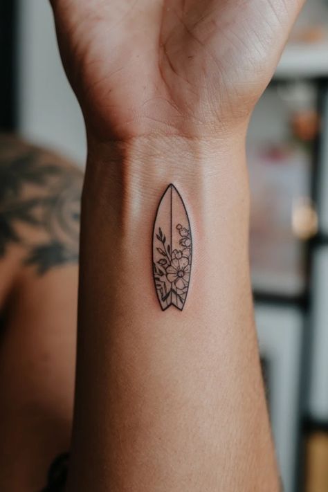 Minimalist surfboard tattoo with floral design on a person's arm. Best Friend Hawaii Tattoo, Small Skateboard Tattoo, Costa Rica Tattoo Ideas Pura Vida, Paddle Board Tattoo Ideas, Surf Tattoos For Women, Adventure Tattoos Women, Wave Tattoo On Foot, Wakeboard Tattoo, Paddle Board Tattoo