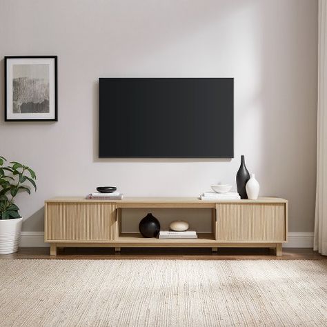 Whether youre into art-deco design, Japandi interiors, or a modern motif, this is the TV stand youve been looking for. With its sleek and subtle hardware, reeded double doors, and fuss-free open storage cubby, your tech will be perfectly perched in style. Its low-profile leaves room for you to display your wall-mounted TV, dcor, or wall art, yet it offers enough open and closed storage for all your entertainment center essentials. A warp-resistant MDF wood build and stunning yet durable laminate finish lends form, function, and a fashionable aesthetic. Available for Online Purchase Only. Ships Directly from the Manufacturer. RC Willey Delivery is Not Available. Assembly required. Made with warp-resistant MDF and durable laminate Fluted-door lends a luxe look Minimalist metal hardware Accom Natural Wood Entertainment Center, Organic Modern Tv, Japandi Tv Cabinet, Living Room Tv Stand Decor, Aesthetic Tv Stand, Light Living Room Ideas, Minimalist Entertainment Center, Scandinavian Tv Stand, Fluted Door