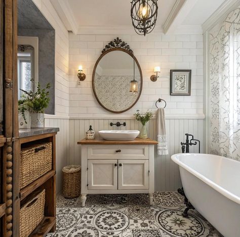 An elegant, vintage-style bathroom featuring a freestanding clawfoot tub with decorative metal feet. The room has a beautifully carved ceiling with intricate designs, a carved wooden cabinet with shelves for towels and plants, and white subway tile walls with a decorative border. Hanging pendant lights add a warm glow, and a ladder-style towel rack and vintage fixtures enhance the old-world charm. The door has carved details that match the ornate ceiling for a cohesive, luxurious feel. Claw Tub Bathroom Ideas Farmhouse, Oval Bathroom Mirror Ideas, Country Modern Bathroom, Claw Tub Bathroom Ideas, Vintage Bathroom Tiles, Small Bathroom With Clawfoot Tub, French Bathroom Design, Black And White Bathroom Tile, French Country Bathroom Ideas