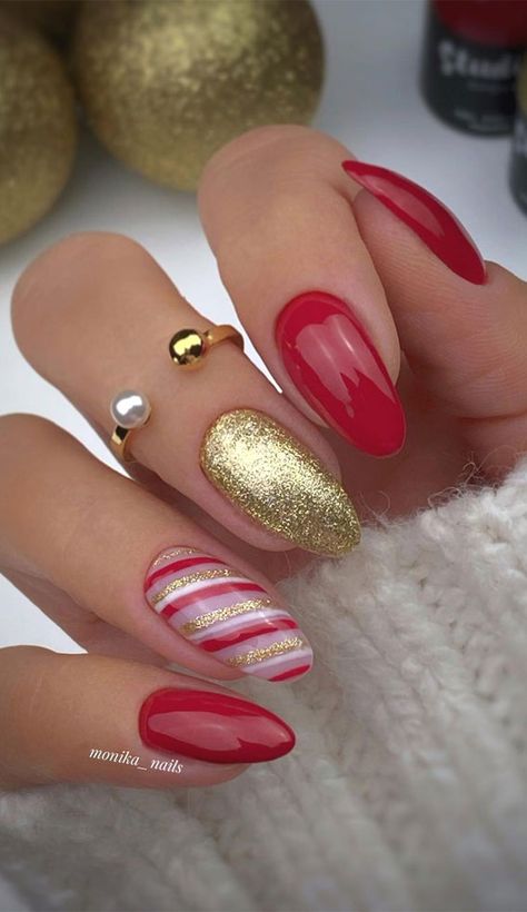 39. Gold and Red Christmas nails A pretty, stylish festive nail set. The nails feature red and gold glitter nails. One nail has candy... Festive Nail Colors, Nail Art Noel, Red And Gold Nails, Candy Cane Nails, Red Christmas Nails, Christmas Nails Easy, Christmas Gel Nails, Nails Easy, Christmas Nails Acrylic