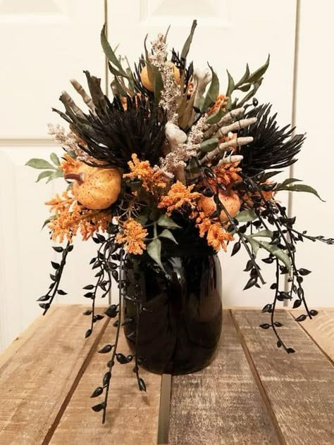 18 Stylish Halloween Table Centerpiece Ideas » Lady Decluttered Black Flowers Halloween Decor, Halloween Theme Centerpieces, Chic Halloween Centerpiece, Halloween Fake Flower Arrangement, Halloween Dried Flowers, Simple Halloween Centerpieces For Table, Halloween Flowers Arrangements, Fall Floral Arrangements Diy, Cauldron Flower Arrangement