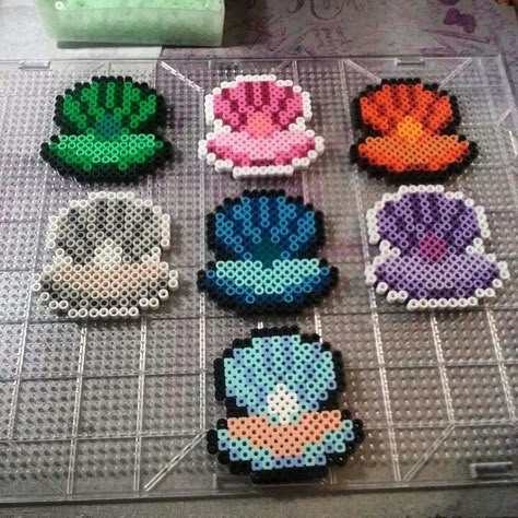 Les contours blanc du coquillage violet seront en orange foncé, les contours du coquillage rose seront en vert clair, les contours du coquillage gris seront en rouge Aesthetic Fuse Bead Patterns, Shell Perler Beads, Beach Perler Beads, Ocean Perler Beads, Perleplader Ideas, Melty Bead Designs, Melt Beads Patterns, Hamma Beads Ideas, Easy Perler Bead Patterns