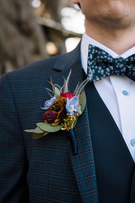 Burgundy And Blue Boutonniere, Burgundy Navy Gold Boutonniere, Jewel Tone Buttonhole, Dark And Moody Boutonniere, Blue Thistle Boutonniere Groomsmen, Spray Roses Boutonniere, Boutonniere Ideas, Blue Boutonniere, Groom's Boutonniere