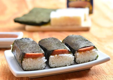 Spam Musubi- a popular Hawaiian snack, a slice of spam is cooked in soy sauce and laid over a rectangular block of short grain rice then wrapped in nori seaweed for an island take on traditional sushi Spam Musubi Recipe, Musubi Recipe, Hawaiian Snacks, Kawaling Pinoy, Sushi Style, Spam Recipes, Sushi Roll Recipes, Spam Musubi, Nori Seaweed