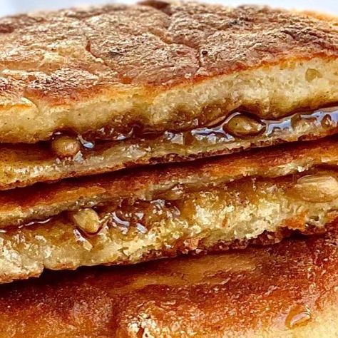 Stella Navarro-Kim on Instagram: "My hotteok recipe is finally here!! Hotteok is a Korean sweet pancake made with a yeasted dough and filled with a gooey, brown sugar filling. The dough is light and crispy on the outside and chewy in the inside, kinda like mochi doughnuts. My mom made these A LOT growing up. Too much almost. I’ve had so many haha This is a very popular Korean street food that has many different variations now. Some street vendors make them filled with cheese, red bean, or savory items like curry or japchae. I sometimes like to put a scoop of ice cream, fold it in half and enjoy as a hotteok ice cream sandwich! Soooo good! My favorite is the classic sweet version, and I love them with sunflower seeds! You can add whatever nuts or seeds you prefer- it is commonly made wit Hotteok Recipe Korean Pancake, Hotteok Recipe, Korean Pancake, Scoop Of Ice Cream, Street Vendors, Korean Street Food, Honey Nut, Cream Sandwich, Red Bean