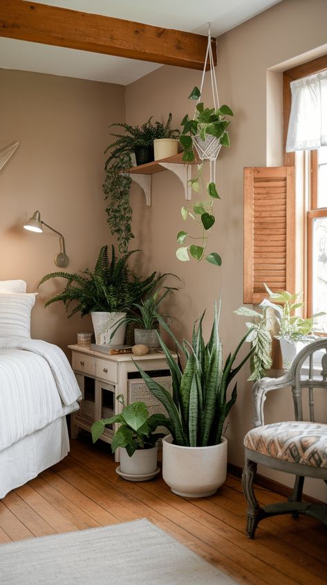 Cozy bedroom with lush greenery and potted plants Plant In Bedroom, Plant Bedroom Aesthetic, Bedroom With Plants, Bedroom 2025, Cottage Bedroom Ideas, Plants In Bedroom, Cozy Cottage Bedroom, Rustic Stone Fireplace, Plant Bedroom