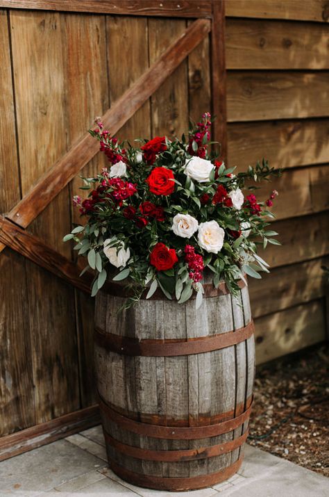 A Rustic And Elegant Barn Wedding In Bayou Country Wine Barrels With Florals And Barn Floral Arrangement On Wine Barrel, Christmas Wedding Arbor Ideas, Christmas Wedding Rustic, Christmas Country Wedding Ideas, December Wedding Decorations Wedding Table Decor, Christmas Rustic Wedding, Country Christmas Wedding Ideas, Christmas Wedding In Florida, Rustic Red Wedding Decor