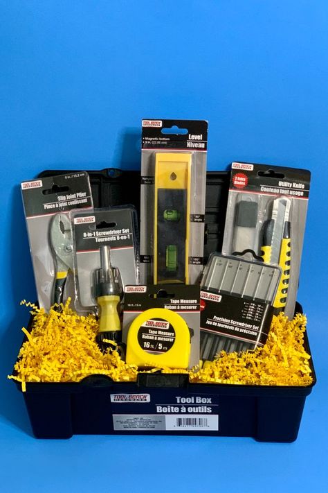 This black plastic tool box with yellow clasp and handle is the perfect father's day gift and it contains: A pair of slip joint pliers, an 8-in-1 screwdriver set, A lever, A utility knife with 2 extra blades, a tape measure, and a precision screwdriver set. The toolbox is sized as follows: Length: 12 in. Width: 4.5 in. Height: 4 in. Diy Father's Day Gift Baskets, Tool Box Gift, Honey Do Shower, Dad Gifts Basket, Fundraiser Baskets, Fathers Day Gift Basket, Raffle Basket, Diy Father's Day Gifts, Diy Basket