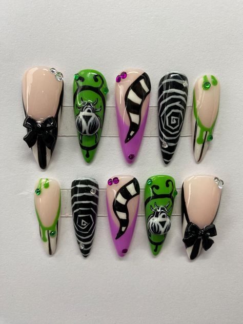 There hand painted press on nails are reusable and last up to three + weeks. These nails are incredibly strong and are so perfect for the upcoming beetlejuice movie coming out💜💚 These nails include 3D designes and are spooky enough for the Halloween season 🖤 All of my sets include a protective travel case, a mesh bag and nail glue for application🤍 I send all of my sets though Royal Mail Standard Delivery which usually takes about 2-3 days to deliver to your door once the product is out of my Beetlejuice Press On Nails, Halloween Movie Nail Designs, Halloween Ideas Nails, Halloween Nail Designs Beetlejuice, Halloween Nails Bettle Juice, Beetlejuice French Tip Nails, Back To The Future Nails, Frankenweenie Nails, Beetlegeuse Nails