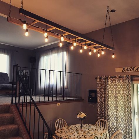 Lights Wrapped Around Beam, Ladder Hanging From Ceiling With Lights, Ladder Lights Hanging Kitchen, Ladder Lights Hanging, Ladder Ceiling, Ladder Light Fixture, Ladder With Lights, Old Ladder Decor, Rustic Lighting Ideas