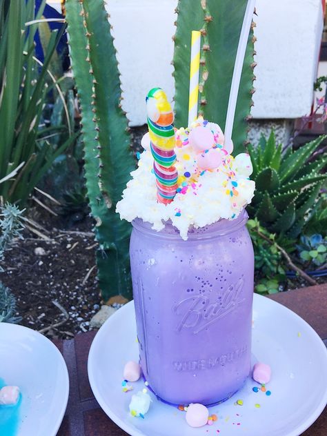 Unicorn milkshake in purple mason jar topped with whipped cream, sprinkles, lollipop and marshmallows. #unicornfoods #unicornmilkshake #unicorns #partyfood #unicornparty #unicorntreats #unicornpartytreats  livingmividaloca.com Purple Milkshake, Candy Milkshake, Unicorn Bark, Unicorn Milkshake, Unicorn Food, Unicorn Desserts, Rainbow Food, Unicorn Foods, Fancy Drinks