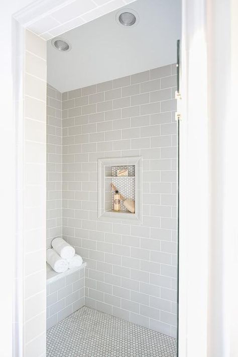 A glass door opens to a walk-in shower clad in light gray subway wall tiles fixed surrounding a tile framed niche covered in mini white hex tiles. Subway Tiles Bathroom, Bad Inspiration, Shower Niche, Bathroom Shower Tile, Bathroom Remodel Shower, Home Luxury, Subway Tiles, Upstairs Bathrooms, Bathroom Redo