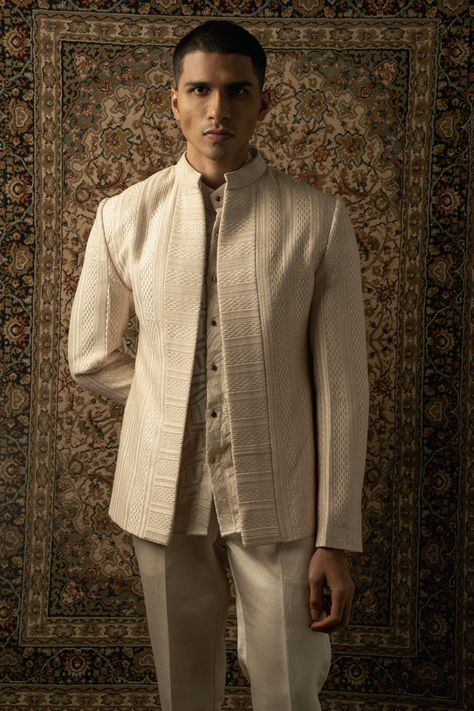 The ivory-layered ensemble exudes a graceful fusion of traditional and contemporary elements, with an unmistakable Indo-Western essence. Crafted from luxurious silk fabric, each layer of the ensemble is adorned with intricate tonal silk thread embroidery, adding an exquisite touch of elegance and sophistication.The ensemble features a stylish kurta with a modern twist, boasting a silhouette that effortlessly blends Eastern and Western influences. The fine embroidery enhances the allure of the ku Indowestern Outfits For Men, Indo Western Outfits For Men, Indian Wedding Suits Men, Kurta And Pants, Indian Wedding Clothes For Men, Silk Thread Embroidery, Wedding Kurta For Men, Party Outfit Men, Wedding Dresses Men Indian