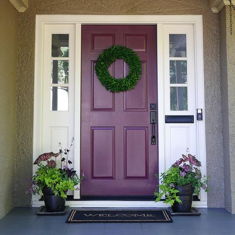 By choosing a color for the front door with similar undertones like muted maroon Kung Fu | 0109, the door now complements the body color instead of fighting against it. Maroon, burgundy, and plum tones are solid sophisticated alternatives to classic red for front doors. On the color wheel, purple is opposite of yellow and therefore they are complementary colors. That means when paired near or next to each other, they activate each other. Plum Paint Colors, Plum Paint, Exterior Color Combinations, Light Vs Dark, Grey Siding, Front Porch Makeover, Blue Front Door, Porch Colors, Porch Makeover