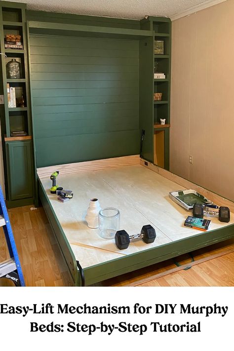 Easy-Lift Mechanism for a DIY Murphy bed in a home setup with weightlifting equipment and tools on the bed frame. Murphy Bed Measurements, Murphy Bed And Playroom, Bed That Goes Into Wall, Flex Room With Murphy Bed, Craft Room Ideas With Murphy Bed, Bed On Wall Ideas, Murphy Beds For Small Spaces Bedroom, Bonus Room Murphy Bed, Murphy Bed Tv Stand