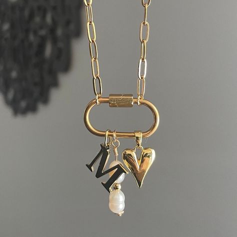 The Keepsake Necklace features a personalized initial charm and a convenient carabiner to easily add any other favorite charms you have. This necklace serves as a special container for all your cherished memories through charms. Featuring: Openable Carabiner with a Gold Plated Stainless Steel Initial Charm, a Long Pearly Charm, & our 18k gold plated Dainty Heart charm. The necklace is 16 inches long. Although this piece is made with water resistant materials, we always recommend to take pieces o Chunky Necklace Gold, Gold Charms For Necklace, Carabiner Charm Necklace, Dainty Charm Necklace, Chunky Cross Necklace, Christmas Gifts For Best Friends, Personalized Jewelry For Mom, Memory Necklace, Carabiner Necklace