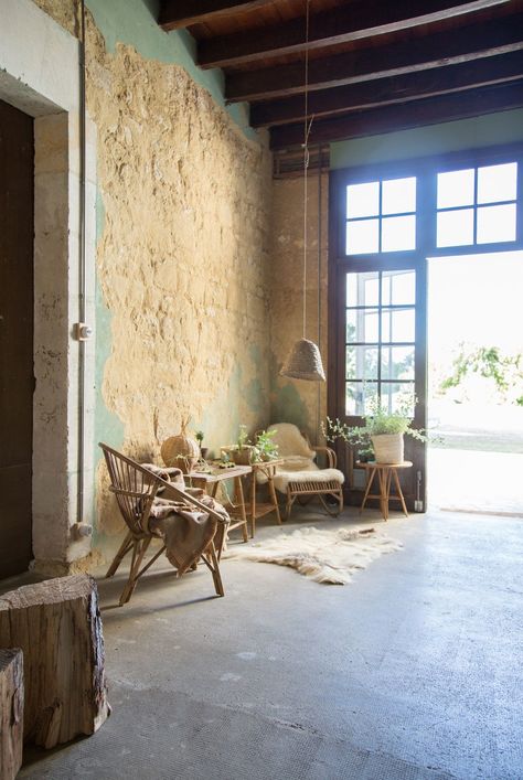 Rattan chairs piled with cozy blankets sit in front of a richly textured stone wall | archdigest.com Unfinished Wall, Rustic Outdoor Spaces, Peeling Wallpaper, Hallway Chairs, Texture Stone, Romantic Interior, English Interior, New Romance, Simple Wall Decor