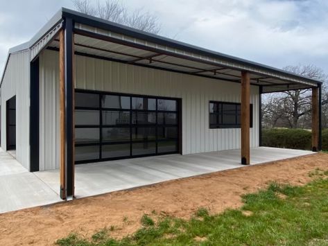 Metal Gym Building, Metal Shop With Patio, Shop With Patio, Metal Building Rec Room, Metal Building Workshop Ideas, Metal Building Salon, Metal Building With Glass Garage Doors, Metal Building With Lean To, White Metal Shop With Black Trim