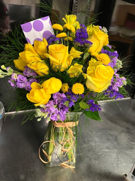 Yellow Roses, Yellow Button Mums, Purple Stock, Purple Statice, Yellow Aloestomeria, Tree Fern Yellow Roses Flower Arrangements, Yellow Purple Flower Arrangement, Yellow And Purple Flower Arrangements, Purple And Yellow Flower Arrangements, Purple And Yellow Bouquet, Yellow Roses Arrangement, Purple Statice, Yellow Flower Arrangements, Yellow Rose Bouquet