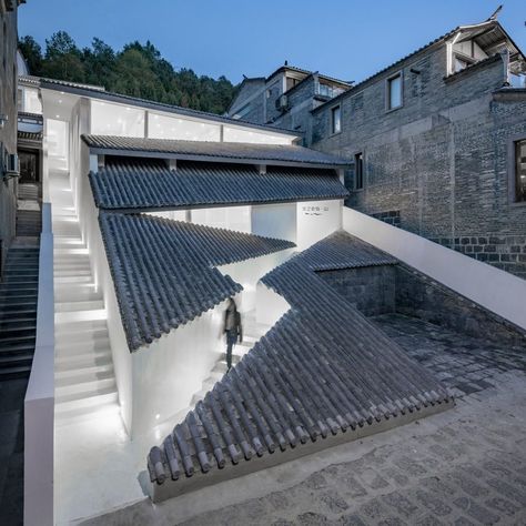 Studio QI cuts zigzagging entrance into sloped tiled roof of Annso Hill Hotel Slope Building Architecture, Architecture On A Slope, Sloped Architecture, Slope Building, Hill Architecture, Entrance Architecture, Roof Architecture, Wooden Cabins, Entrance Ways