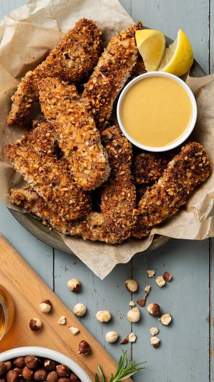 Hazelnut Crusted Chicken, Nut Crusted Chicken, While Chicken, Caramelized Honey, Baked Chicken Strips, Honey Mustard Sauce, Crusted Chicken, Chicken Strips, Glass Baking Dish