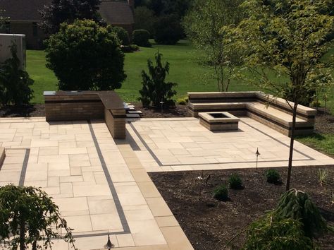 1,100sf two tiered paver patio with 10ft long bar, drop in cooler, rectangular fire pit and large "L" shaped sitting wall with backrest.    Techo-bloc material was used for construction.  Aberdeen pavers color baja beige were used for the main patio areas.  Linea pavers color onyx black were used as an accent strip in the patio.   Raffinato wall block color beige cream and onxy black were used to construct the bar area, fire pit and sitting wall.  Built in Fairview, PA. Tiered Concrete Patio, Diy Stone Patio, Backyard Stone, Concrete Patio Ideas, Sitting Wall, Design Per Patio, Small Patio Design, Brick Paver Patio, Backyard Ideas For Small Yards