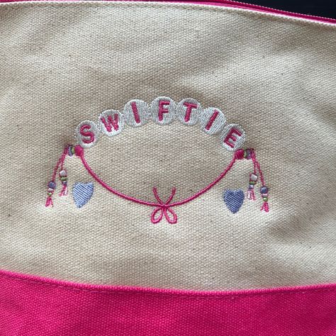 Introducing the Taylor Swift Embroidered Friendship Bracelet Zippered Tote Bag, a blend of style, nostalgia, and functionality! This unique tote collection is inspired by Taylor Swift's iconic lyrics and symbols, reminiscent of the cherished friendship bracelets of youth. http://savyneedleworks.etsy.com #taylorswift #swifties #embroidery Embroidered Taylor Swift Lyrics, Taylor Swift Embroidery Ideas, Embroidered Taylor Swift, Taylor Swift Symbols, Hand Meditation, Taylor Embroidery, Taylor Swift Embroidery, Iconic Lyrics, Crafting Corner