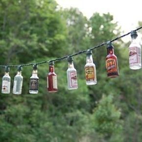 String together some nip lights. | 17 Ways To Have A Crafternoon With A Bottle Of Booze Beer Bottle Lights Hanging, Patio Party Lights, Beer Bottle Lights, Patio Lighting Diy, Liquor Bottle Lights, Camper Lights, Liquor Bottle Crafts, Mini Liquor Bottles, Christmas Lights Garland