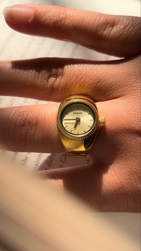 tan hand wearing a gold watch ring by Fossil. It’s a picture focused on the ring while the hand is sitting on a book Ring Watch Women, Fossil Watch Ring, Watch Rings Aesthetic, Finger Watch, Clock Ring, Ring Box Vintage, Watch Rings, Fossil Ring, Watch Ring