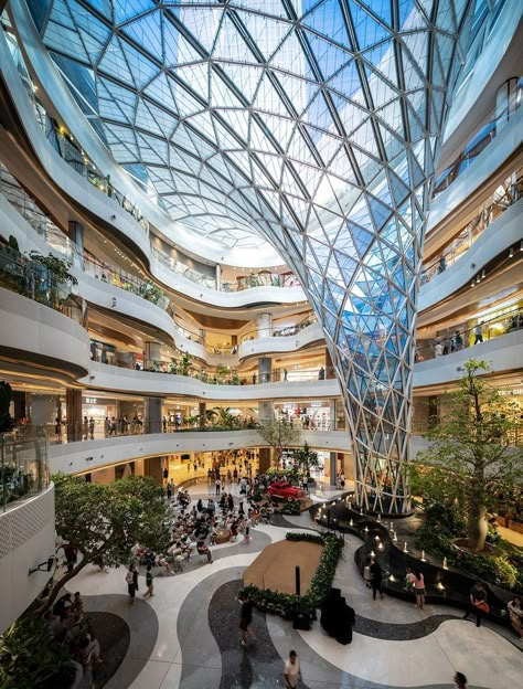 An expansive atrium serves as the heart of this shopping complex. Using unique shapes and materials it brings in natural light and creates a spacious feel for all visitors.  📍Xi'An, China Shopping Center Architecture, Shopping Mall Interior, Mall Facade, Shopping Mall Design, Atrium Design, Shopping Mall Architecture, Retail Architecture, Commercial Complex, Mall Design