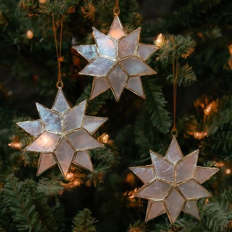 * Set of three capiz shell ornaments * Three dimensional star shape * Measures approx. 4" height * Translucent pearl color * Gold wire details * A hanging loop attached * Traditional capiz shell craft * Made in Philippines ------------------------- Capiz shell crafts are a popular craft in Philippines. Our capiz products are made by artisans working in small producer groups. Capiz is the shell of windowpane oyster. These shells are flat, translucent and have appearence like pearl. These shells w Capiz Shell Crafts, Glowing Star, Pearl Ornaments, Shell Craft, Wine Bottle Topper, Popular Crafts, Mirror With Hooks, Bottle Toppers, Shell Ornaments