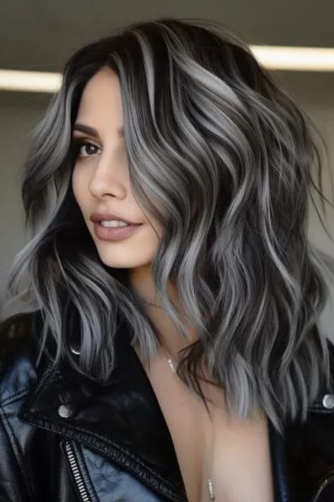 Charcoal black waves with silver streaks make a bold and fashion-forward statement for medium-length hair. Medium barrel curl and texture spray. It is ideal for fine hair and suits a round-shaped face. Click here to check out more trending medium-length wavy hairstyles this year. Very Long Bob, Black And Silver Hair, Charcoal Hair, Black And Grey Hair, Black Waves, Transitioning Hair, Medium Length Wavy Hair, Grey Hair Transformation, Grey Hair Inspiration