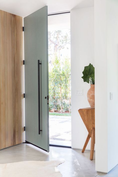 A tall, full-height grey front door with matte black hardware welcomes visitors to this mid-century inspired home. #FrontDoor Scandinavian Doors, Scandinavian Door, Grey Front Door, Green Front Door, Minimalist Entryway, Grey Front Doors, Front Door Ideas, Front Door Hardware, Green Front Doors