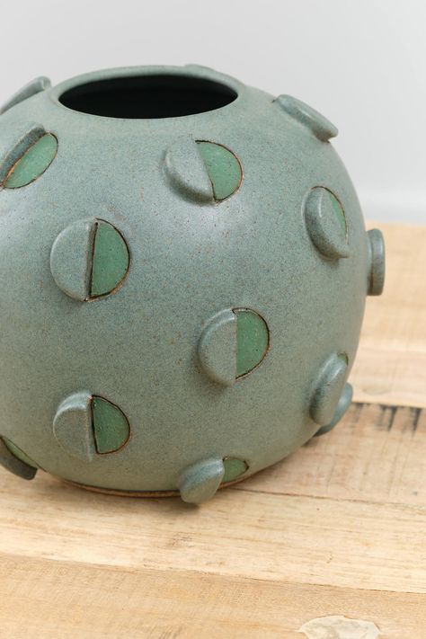 The Barrel Cactus Vase is a large decorative and functional bulbous vase with an abstract circle design throughout in a rich green glaze. Hand-carved and hand-painted geometric and three dimensional circle details adorn the exterior of the vase, finished with a Matthew Ward signature at the base. Ceramic Pouring Bowl, Contemporary Ceramic Vase, Abstract Designs Pattern, Bubble Vase Ceramic, Ceramic Trends 2024, Soft Slab Ceramics Ideas, Carved Ceramic Vase, Hand Built Ceramic Vase, Pinch Pot Projects