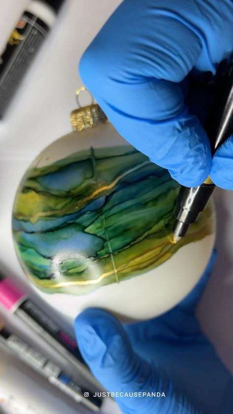 Recently I was making more Christmas decorations with alcohol inks and foils. This one is made on a big (relatively big) white acrylic Christmas bauble. I have painted it with cyan and lemon yellow inks. Lemon yellow is mixed with magenta ink but only 2 drops of magenta, just to make the colour a bit warmer. That added to the blue creates beautiful earthy tones on the bauble. Everything is finished with gold marker and gold transfer foil. Love the end result, such a fun Christmas crafts project 🎄 #alcoholink #alcoholinkart #christmasdecor #christmasdiy #christmasdecorations #crafts #christmascrafts #art #artsy #cuteart #artmaking #artprocess #handmade #alcoholinkcommunity #artprocess #doityourself Glass Ornaments Diy, Diy Christmas Baubles, Alcohol Ink Glass, Handpainted Christmas Ornaments, Alcohol Ink Crafts, Transfer Foil, Handmade Christmas Crafts, Fun Christmas Crafts, Painted Christmas Ornaments